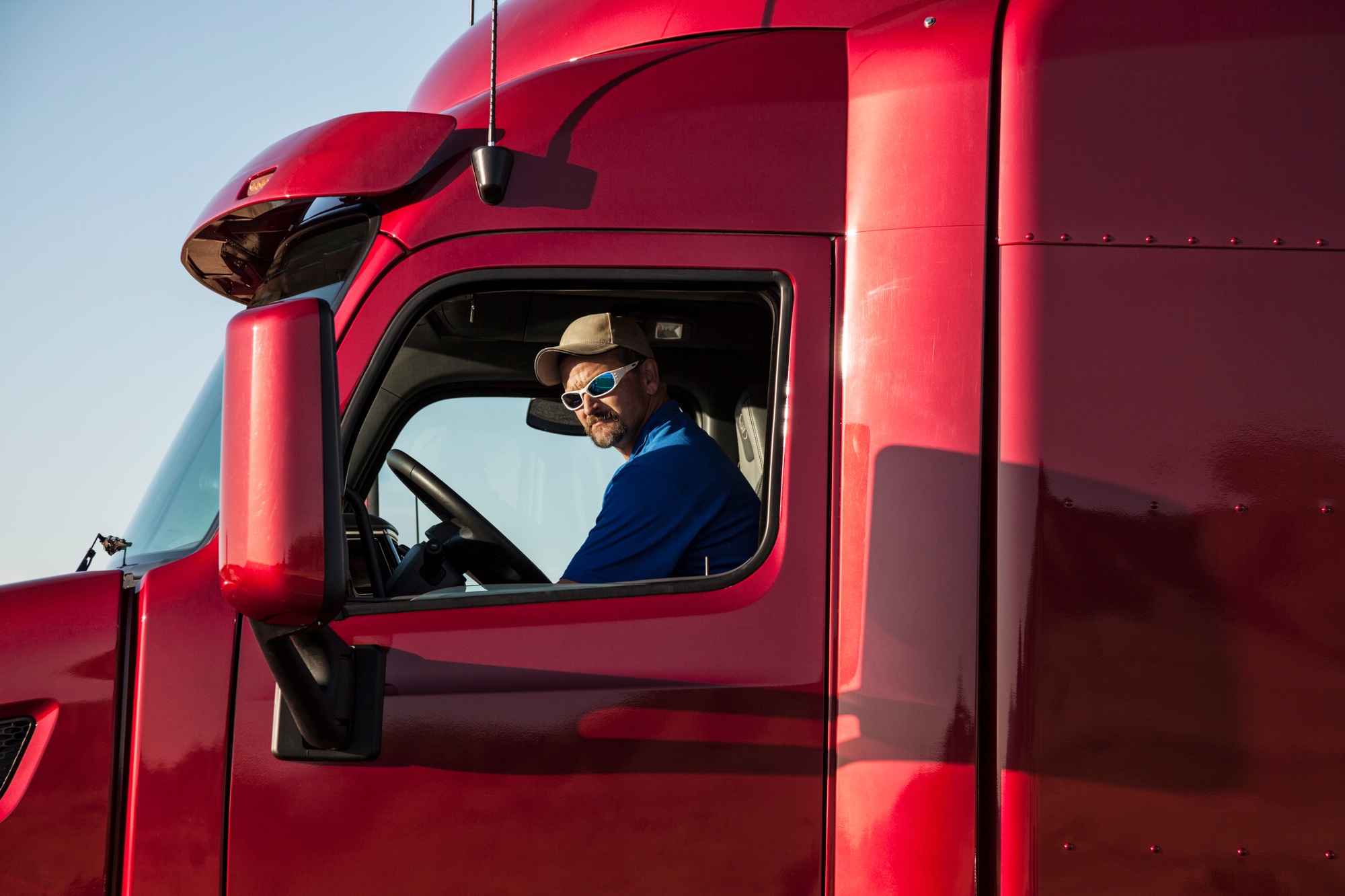 Truck driver, man in a red lorry cab.